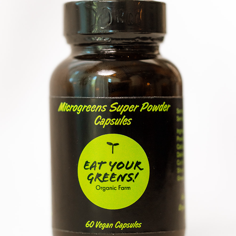 Amber bottle of Microgreens Super Powder Capsules with a black and green label on a white background