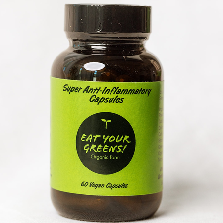 Front of amber bottle with green label of Eat Your Greens Organic Farm turmeric microgreens and ginger capsules