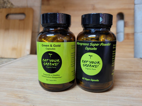 Two bottles of Green & Gold and Microgreens Super Powder capsules by Eat Your Greens Organic Farm in Austin Texas
